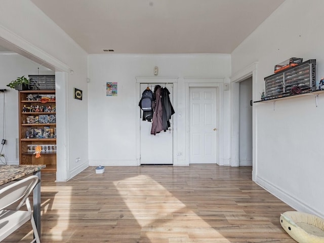 foyer featuring visible vents, light wood-style flooring, and baseboards