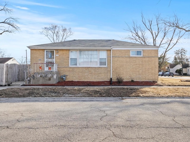 view of front of house featuring fence and brick siding