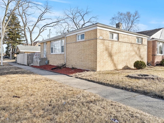 view of side of home featuring brick siding and a chimney