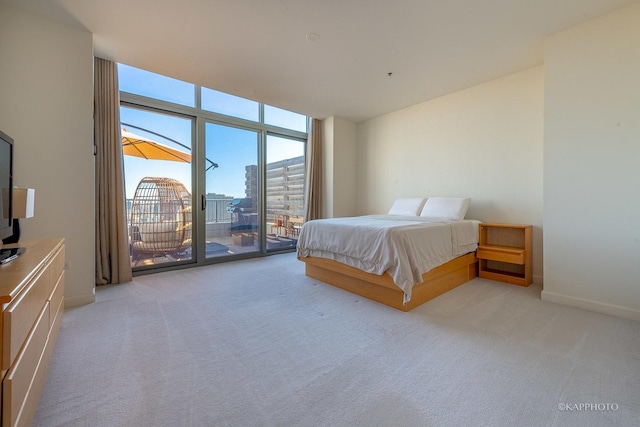 unfurnished bedroom featuring expansive windows, baseboards, light colored carpet, and access to outside
