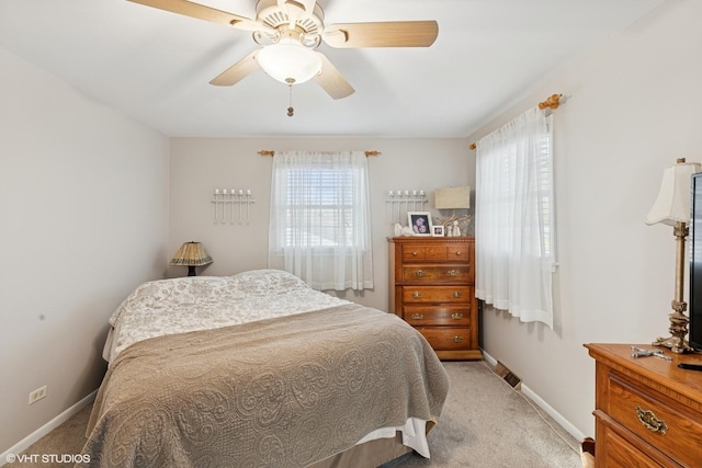 bedroom featuring a ceiling fan, light carpet, and baseboards