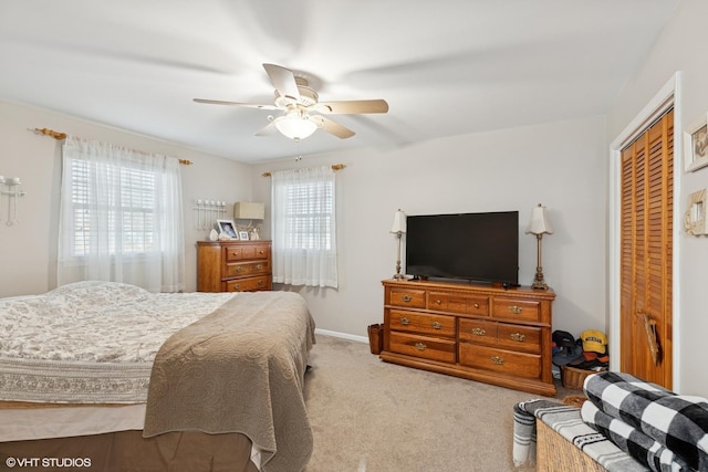 bedroom featuring a closet, ceiling fan, multiple windows, and carpet flooring