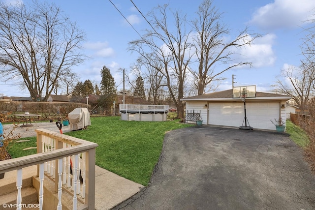 view of yard featuring a garage, fence, a fenced in pool, and an outdoor structure