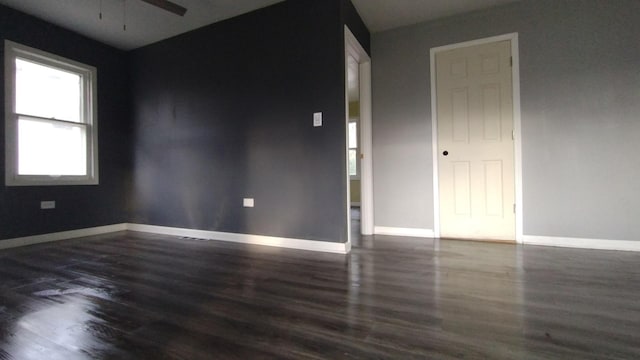 empty room featuring ceiling fan, wood finished floors, and baseboards