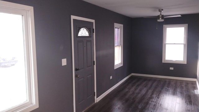 foyer entrance with a ceiling fan, baseboards, and dark wood-type flooring