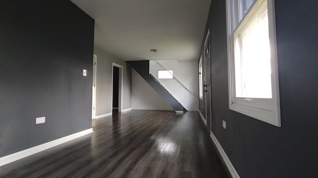 interior space with dark wood-style flooring and baseboards