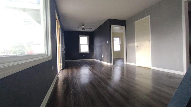 unfurnished room with wood finished floors, a ceiling fan, and baseboards