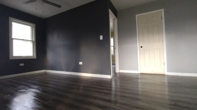 spare room featuring wood finished floors, a ceiling fan, and baseboards