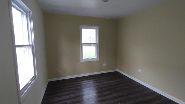 empty room featuring dark wood-style floors and baseboards