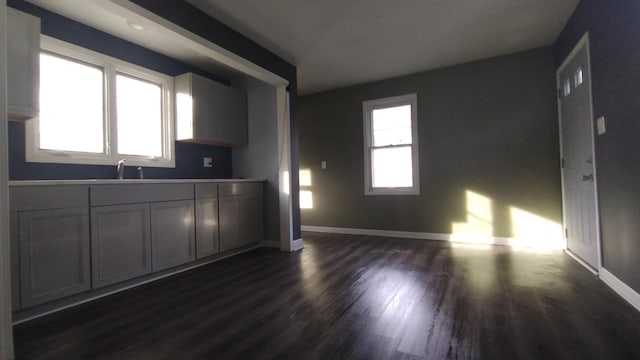 kitchen featuring a sink, dark wood finished floors, and baseboards