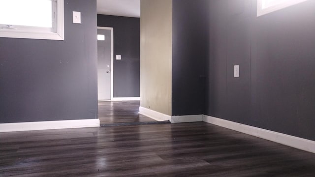 empty room with baseboards and wood finished floors