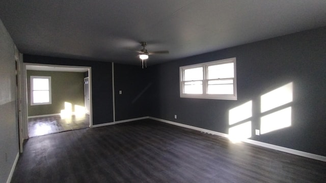 empty room with ceiling fan, baseboards, and dark wood-style flooring