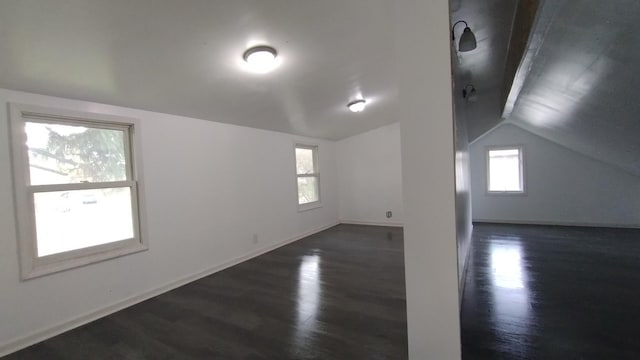 additional living space with dark wood-style flooring, vaulted ceiling, and baseboards