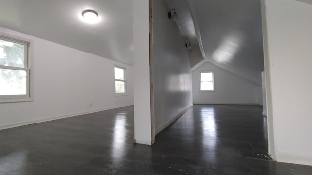 bonus room featuring lofted ceiling, baseboards, and wood finished floors