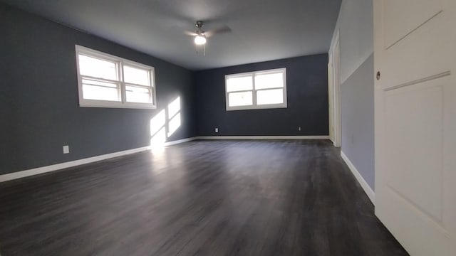 spare room with dark wood-style floors, a ceiling fan, and baseboards