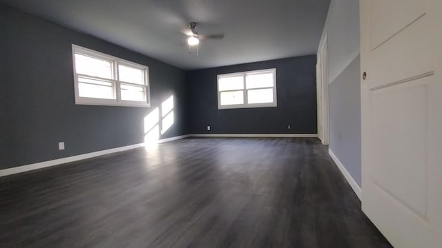 unfurnished room with ceiling fan, dark wood finished floors, and baseboards