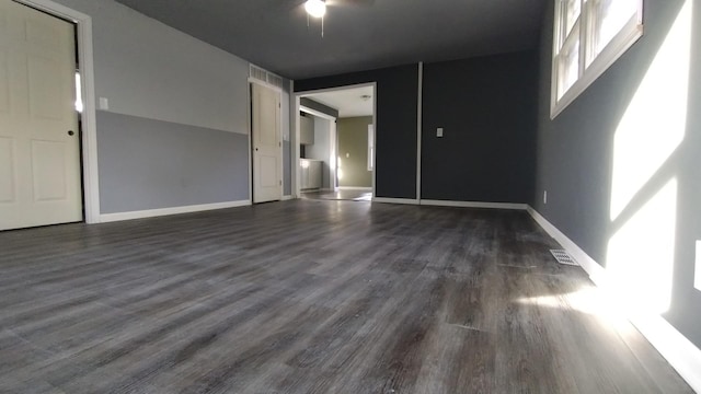 unfurnished room with dark wood-style floors, baseboards, and visible vents