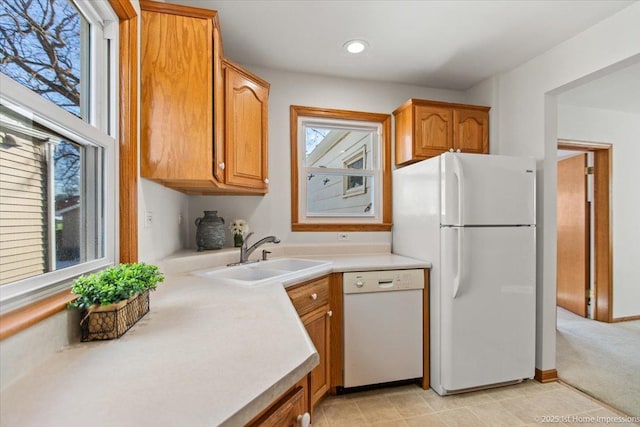 kitchen with light countertops, white appliances, plenty of natural light, and a sink