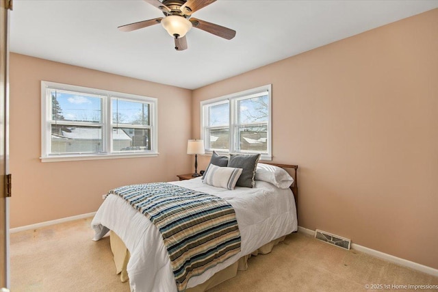 bedroom with light carpet, baseboards, visible vents, and ceiling fan