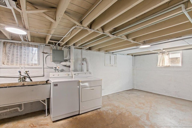 below grade area featuring electric panel, a sink, and washer and clothes dryer