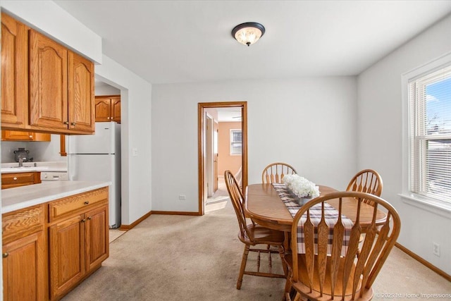 dining space with light colored carpet and baseboards