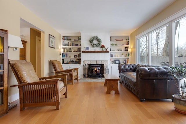 sitting room with built in shelves and light wood-style floors