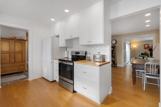 kitchen with tasteful backsplash, light wood-style floors, white cabinets, and stainless steel electric stove