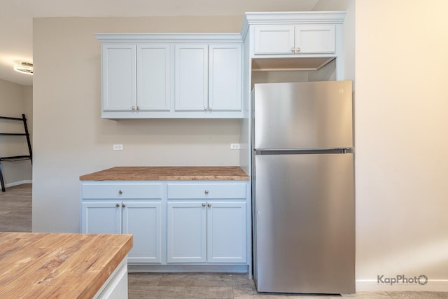 kitchen with butcher block countertops and freestanding refrigerator