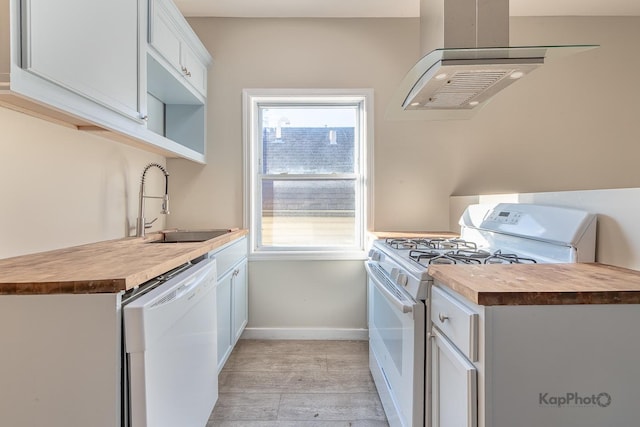 kitchen with a sink, wood counters, ventilation hood, white appliances, and baseboards