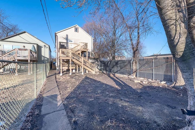 view of yard featuring a deck, stairway, and a fenced backyard