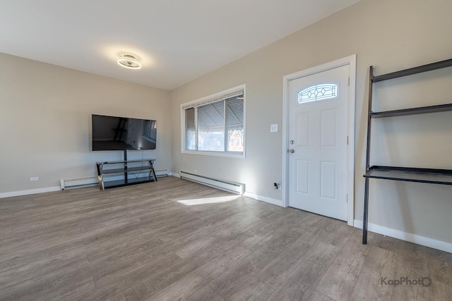 entryway with a baseboard heating unit, baseboards, and wood finished floors