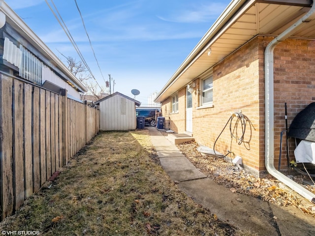 view of property exterior with a storage shed, fence, an outdoor structure, and brick siding