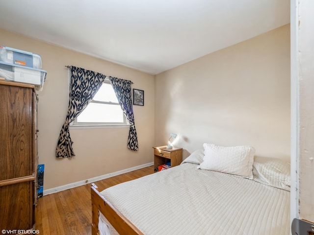 bedroom with wood finished floors and baseboards