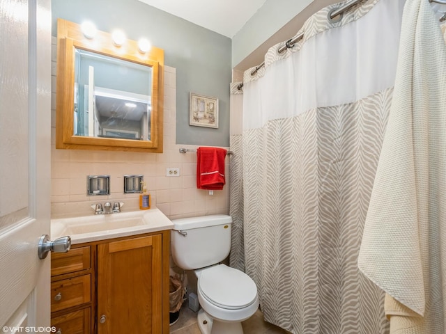 bathroom featuring toilet, tile walls, and vanity