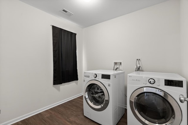 laundry room with laundry area, baseboards, visible vents, washer and clothes dryer, and dark wood finished floors