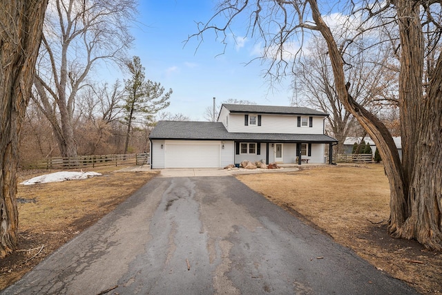 traditional home featuring aphalt driveway, covered porch, fence, and a garage