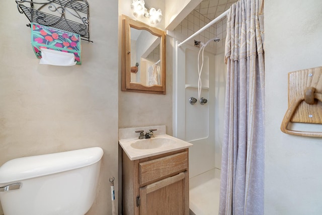 bathroom with a shower stall, toilet, and vanity