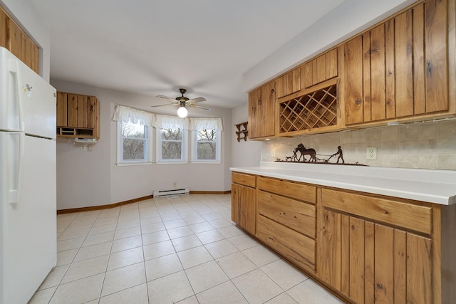 kitchen featuring brown cabinetry, freestanding refrigerator, and light countertops