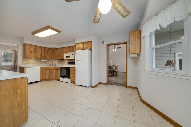 kitchen featuring white appliances, tasteful backsplash, light tile patterned floors, ceiling fan, and light countertops