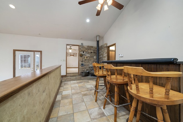 bar featuring vaulted ceiling, ceiling fan, a bar, and recessed lighting