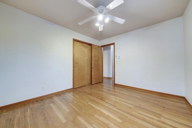 spare room with ceiling fan, light wood finished floors, and baseboards