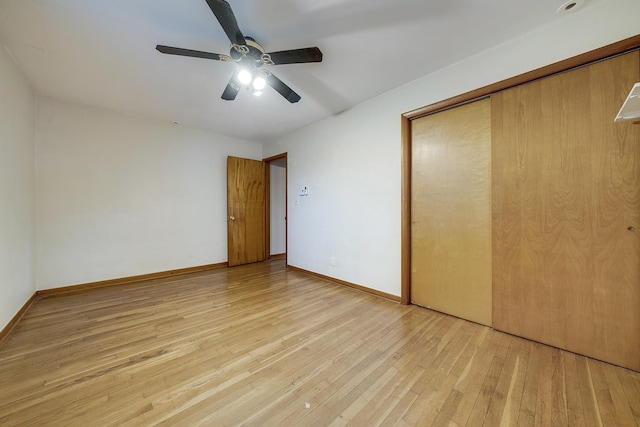 unfurnished bedroom with a closet, wood-type flooring, baseboards, and a ceiling fan