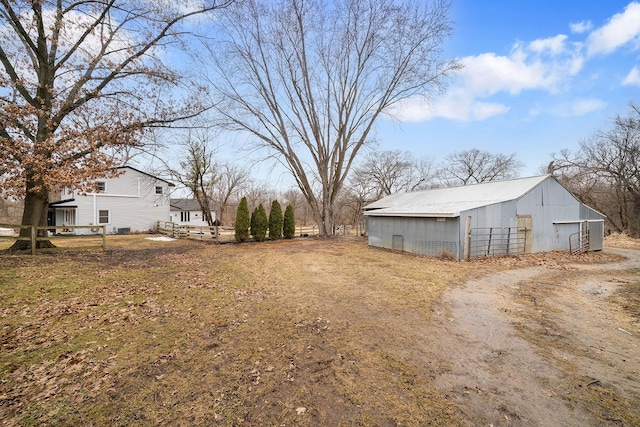 view of yard with a detached garage, a pole building, and an outbuilding