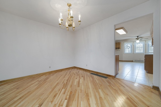 empty room featuring a baseboard heating unit, visible vents, light wood-style floors, and baseboards