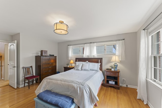 bedroom with light wood finished floors and baseboards