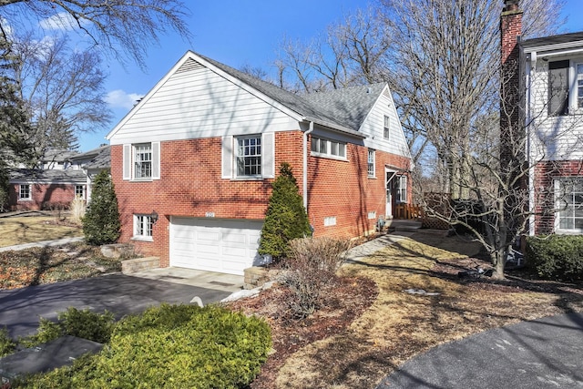 view of home's exterior with driveway, brick siding, an attached garage, and a shingled roof