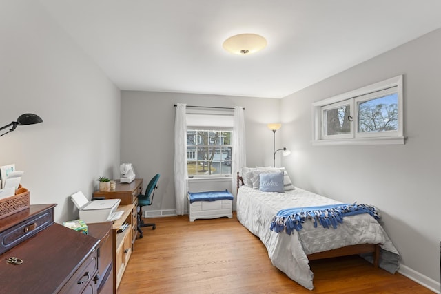 bedroom with light wood-type flooring, visible vents, and baseboards