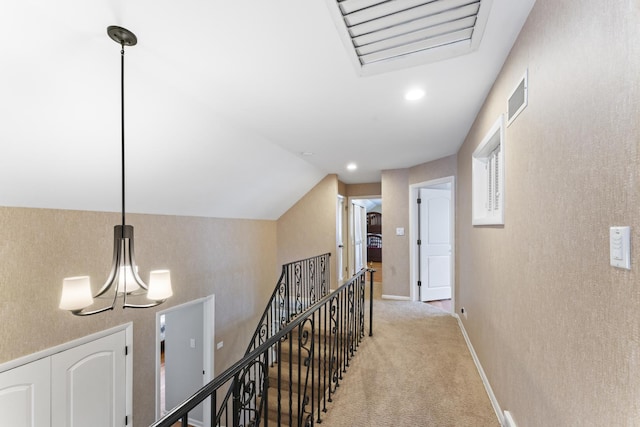 hall with carpet, visible vents, vaulted ceiling, and an upstairs landing