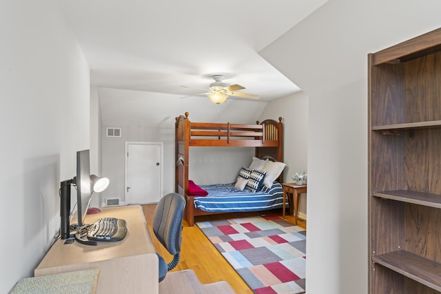 bedroom with lofted ceiling, ceiling fan, visible vents, and wood finished floors