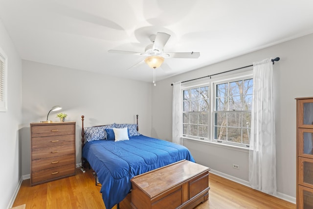 bedroom featuring a ceiling fan, light wood-style flooring, and baseboards